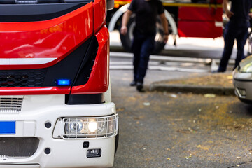 Emergency response team operates fire truck in urban setting during daylight hours to address...