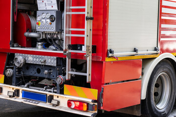 Red fire truck rear with equipment showing during an emergency response in a city street