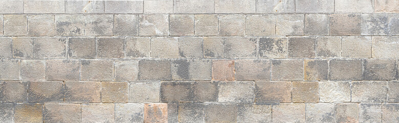 Old stone brick wall forming a seamless texture background