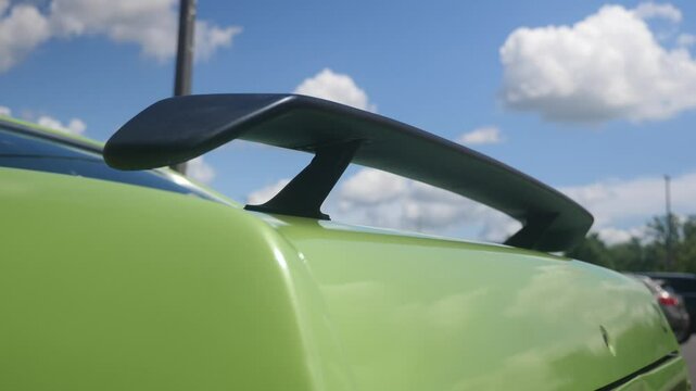 Car rear wing adds style to vibrant green vehicle