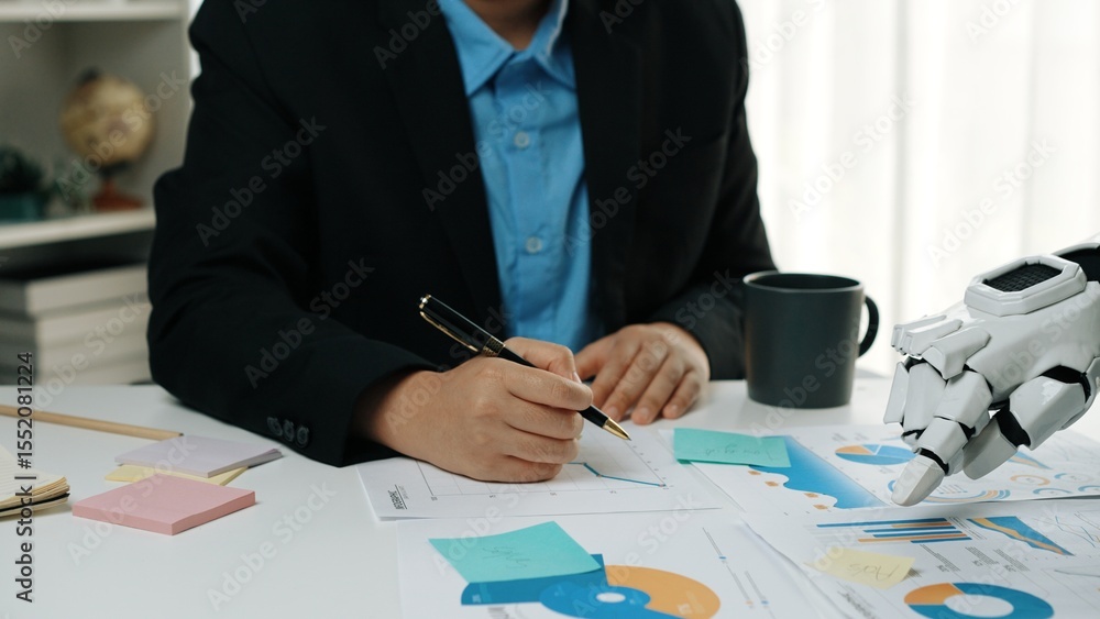 Poster a business professional engages in data analysis using a robotic hand, with charts and notes around 