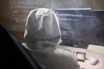 A young programmer codes intently in a dark setting, immersed in his work and creativity