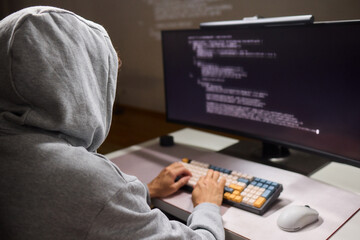 A young programmer codes intently in a dark setting, immersed in his work and creativity