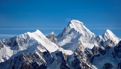 Obraz premium a majestic snow covered mountain range with sharp towering peaks under a clear blue sky