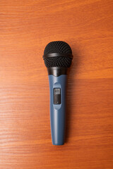 Microphone resting on a wooden surface, ready for a performance or recording session in a studio...