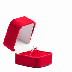 Elegant diamond engagement ring in a red velvet box on a white background. Symbolizes love and...