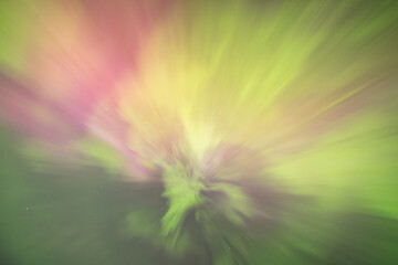 Bands of northern lights dance across the night sky in vibrant shades of green and violet.