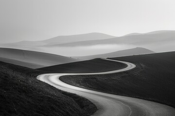 Winding road through rolling hills and valleys fading into the misty distance