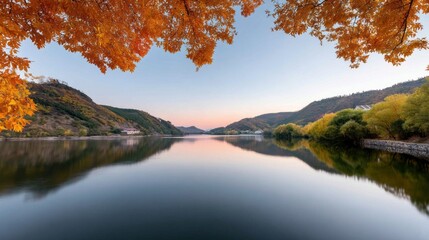A beautiful lake with a reflection of the sky and trees. The sky is orange and the water is calm
