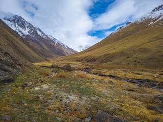 Majestic Kyrgyzstan mountains and serene valley with flowing stream