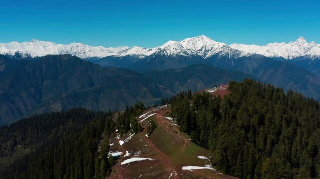 Scenic drone view of Makra Mountain in Siri Payee, with dense plants and scattered snow
