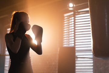 Women self defense girl power. Strong woman fighter training punches on boxing ring. Healthy strong girl punching boxing bag. Training day in boxing gym. Strength fit body workout training