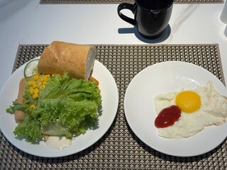Western-Style Breakfast with Salad, Sausages, Fried Egg and Coffee