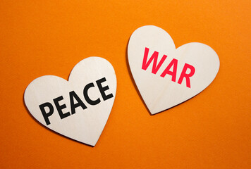 War or Peace symbol. Concept word War or Peace on wooden hearts. Beautiful orange background....