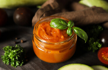 Homemade tomato sauce, jar of homemade vegetable spread or sauce with basil - rustic style 