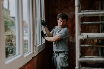 A man closes a plastic window after repairs.