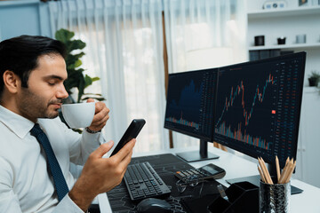 Trader businessman holding coffee cup focusing on dynamic on phone, stock exchange investment...
