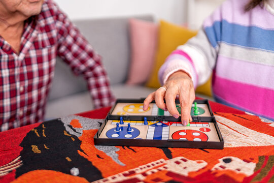 Senior couple playing ludo board game at home