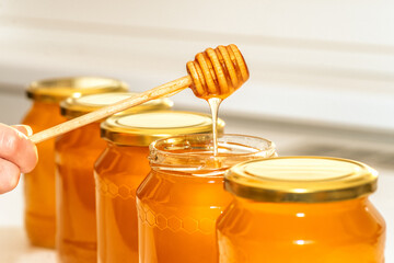 Honey in bottles. Honey dipper