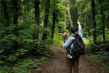 girl travels through the forest with a child and a backpack.family travel.family concept