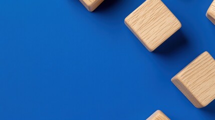 Abstract wooden blocks on vibrant blue background, symbolizing creativity and minimalism.