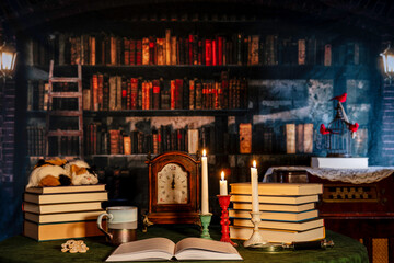 open book and burning candles with coffee and cookie and old library background