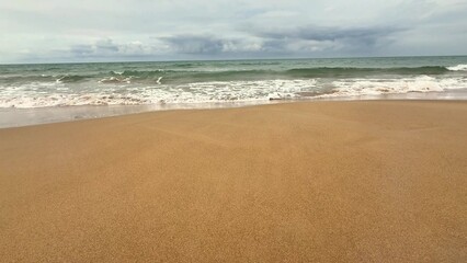 A peaceful and serene beach scene with gentle waves lapping at the soft shore, creating a truly tranquil atmosphere