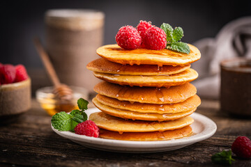 Healthy summer breakfast, homemade classic american pancakes with fresh berries and honey. High quality photo