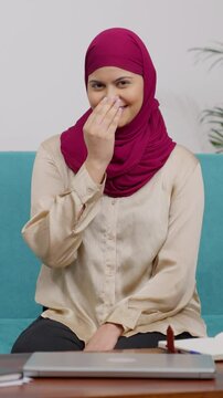 Vertical Video of Happy Muslim Woman in Hijab Scarf Sitting on Couch Greeting Adab