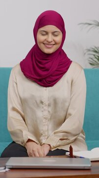 Vertical Video of Muslim Woman in Hijab Scarf Sitting on Couch Greeting Adab