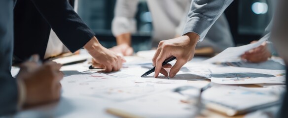 The focused hands collaborating on a project in a dynamic business meeting.