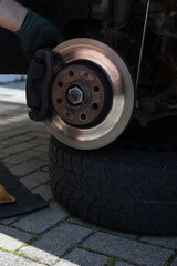 close up of man´s hands reparing the car. worker on the street lifting his car with the jack....