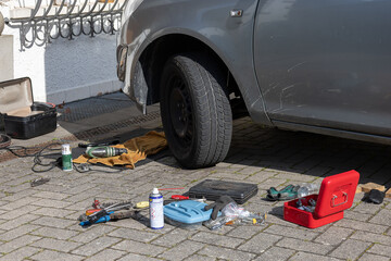 close up of car´s part with a  wheel and all the instruments in the house yard. reparing auto at...