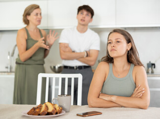 Woman and young guy swear at girl. Mom and older brother scold young girl for unsuccessful studies...