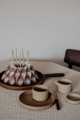 Hausgemachter Geburtstagskuchen mit Kerzen und bunten Dekorationen auf Holztisch – festliche Stimmung, Feier, Dessert und süsses Gebäck bei natürlichem Licht