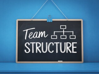 A conceptual representation of organizational hierarchy and teamwork. Team structure diagram on blackboard against blue wall.