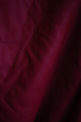 Deep burgundy red leather texture with soft folds and subtle highlights