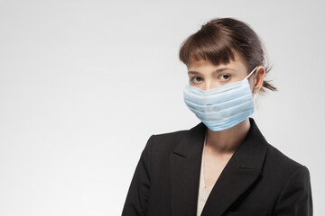 Young businesswoman in mask maintaining professionalism during health crises