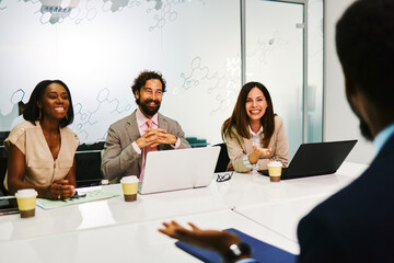 Smiling business people having a conversation during a meeting in a modern office