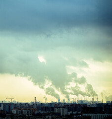 Fototapeta premium Thick smoke rises from industrial chimneys, spreading over the city and polluting the atmosphere. The image powerfully illustrates the impact of air pollution, toxic emissions, and climate change