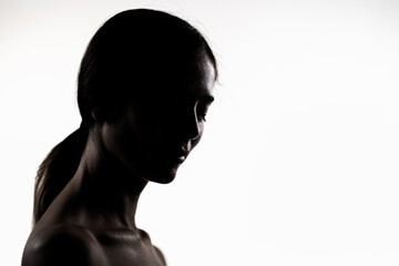 Elegant silhouette of a young woman in a studio portrait, emphasizing beauty and simplicity
