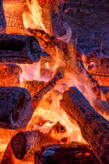 Logs of burning wood burning in a bonfire during a religious festival in honor of Saint John in...