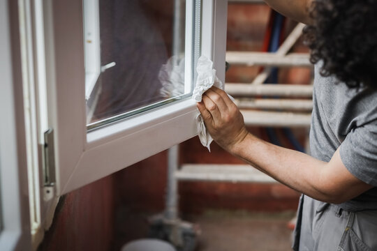 One young worker wipes the window frames with a napkin.