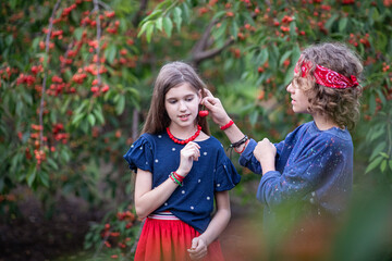 Obraz premium teenage girl and boy in cherry orchard in summer