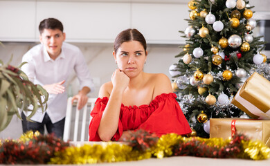 Young couple quarreling - husband expresses displeasure to wife during new year celebration