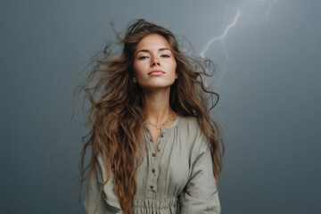 Captivating portrait of a woman with flowing hair against a dramatic stormy background, showcasing strength and beauty in a moody atmosphere