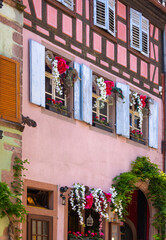 the flower decorated windows of medieval building in Riquewihr, Alsace, France, winery