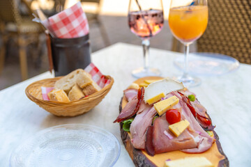 a cold meat board with cheese and vegetables with bread and cocktail in Alsace, France vacation, local cuisine