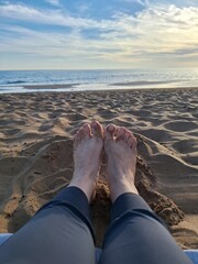 Fototapeta premium feet on the beach as the sun set
