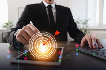 Targeting. Businessman touching aim with arrow on virtual screen over tablet computer at table,...